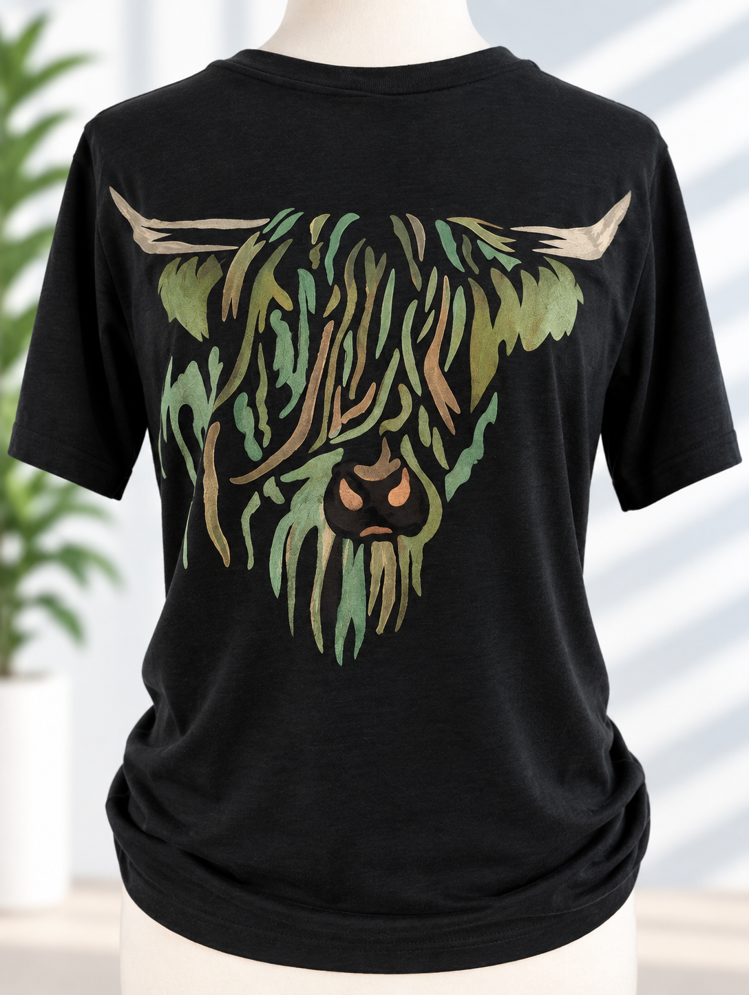 Black t-shirt with hand-painted highland cow design in green and copper tones