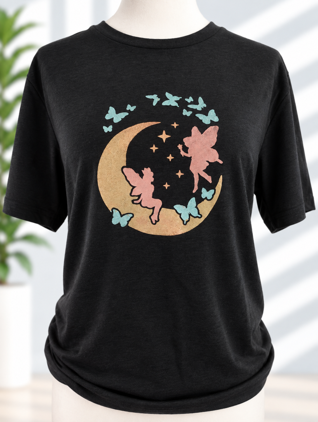 Black t-shirt with hand-painted moon fairies and butterflies design in gold, pink, and teal