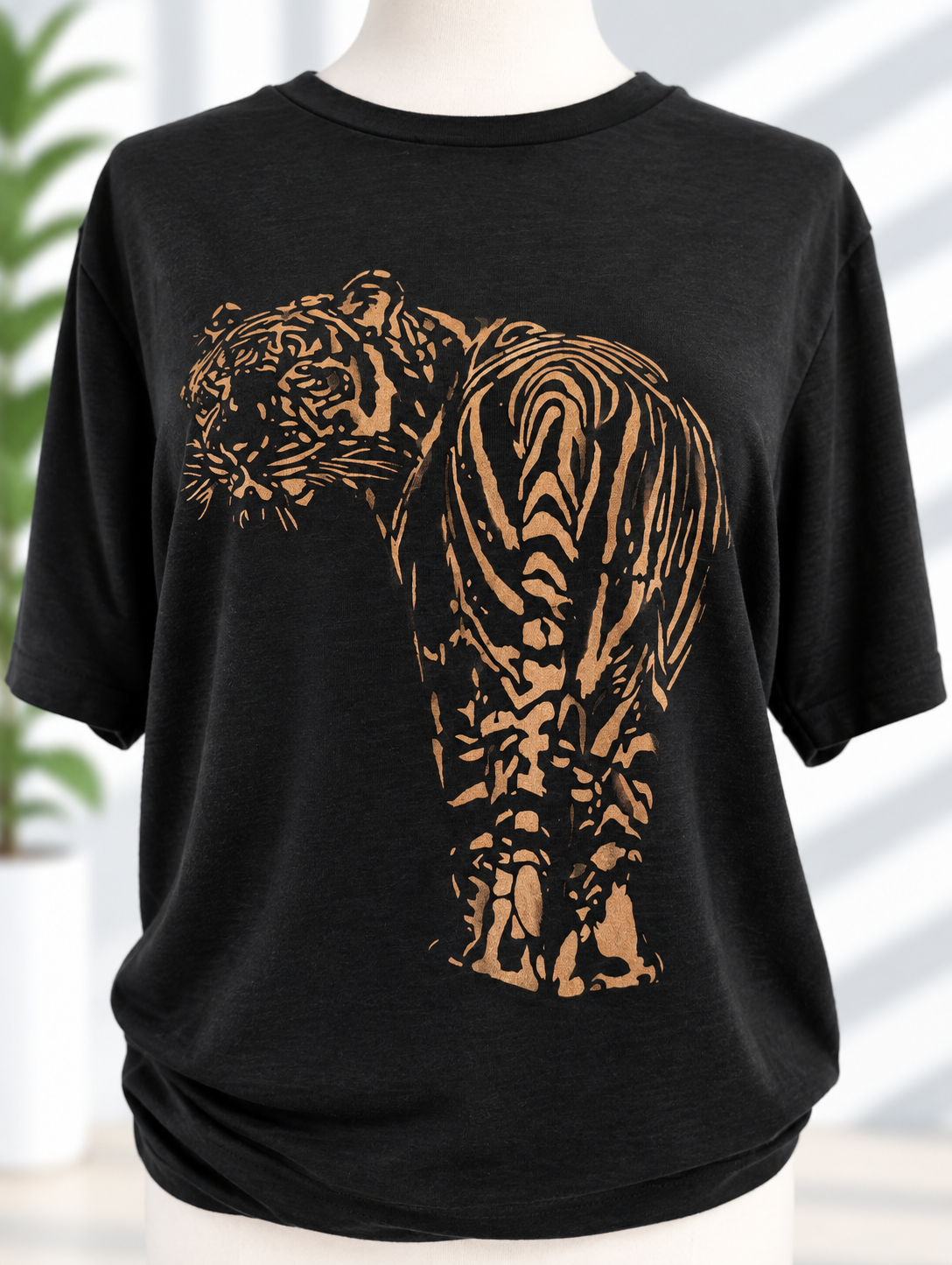 Black t-shirt with hand-painted golden tiger in copper and bronze tones, full body stalking pose
